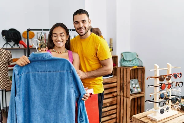 Молодая Латинская Пара Улыбается Счастливо Выбирая Одежду Магазине Одежды — стоковое фото