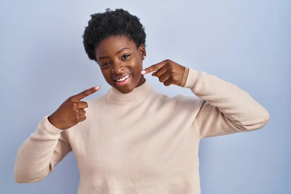 Afro Amerikaanse Vrouw Staat Blauwe Achtergrond Glimlachend Vrolijk Tonen Wijzen — Stockfoto