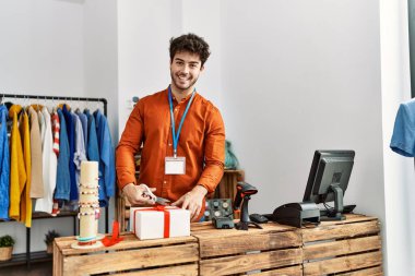 Genç İspanyol esnaf gülümsüyor. Giysi mağazasında mutlu bir hazırlık hediyesi..