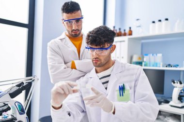 Laboratuvarda çalışan iki bilim adamı.