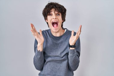 Tecrit edilmiş arka planda duran genç adam çılgın ve başarıyı kollarını kaldırıp heyecanla haykırarak kutluyor. Kazanan konsept 