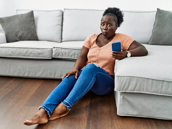 Junge Afrikanerin Mit Smartphone Sitzt Hause Auf Dem Boden Und — Stockfoto
