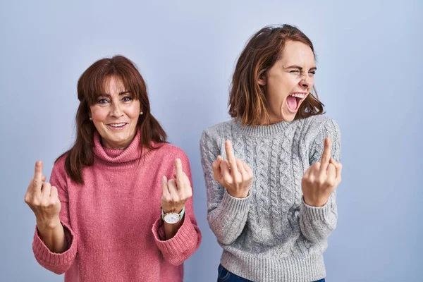 Mother Daughter Standing Blue Background Showing Middle Finger Doing Fuck — стоковое фото