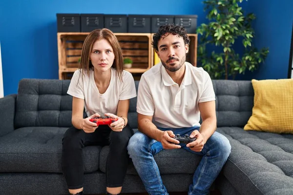 Fiatal Pár Videojáték Holding Vezérlő Otthon Gondolkodás Hozzáállás Józan Kifejezés — Stock Fotó