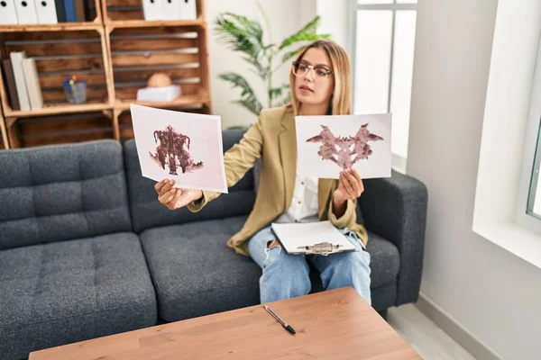 Young hispanic woman psychologist doing rorschach exam at psychology center