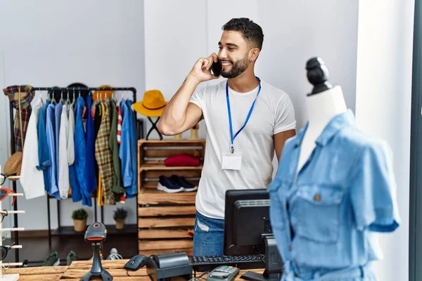 年轻的阿拉伯男子店主在服装店用智能手机交谈 — 图库照片
