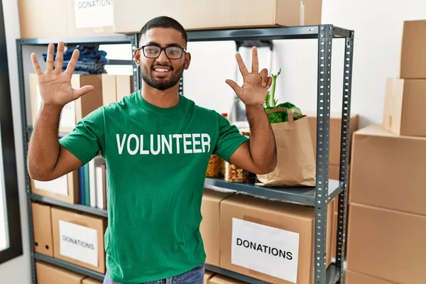 Joven Indio Voluntario Sosteniendo Donaciones Cuadro Mostrando Apuntando Hacia Arriba —  Fotos de Stock