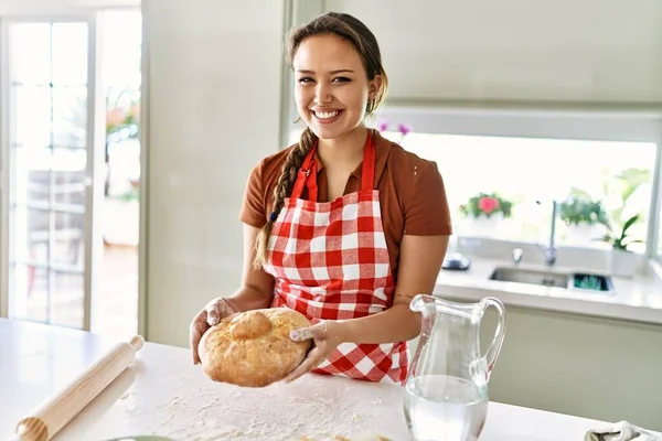 Joven Hermosa Mujer Hispana Sonriendo Confiada Sosteniendo Pan Cocina —  Fotos de Stock