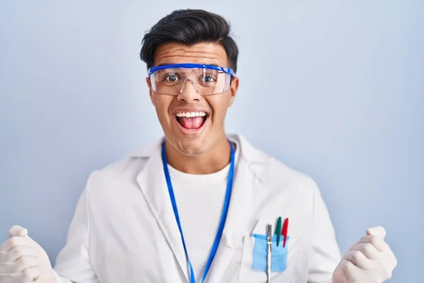 科学者として働いているヒスパニック系の男性は 腕を上げて目を開いて成功に驚いて驚いています 勝者のコンセプト — ストック写真