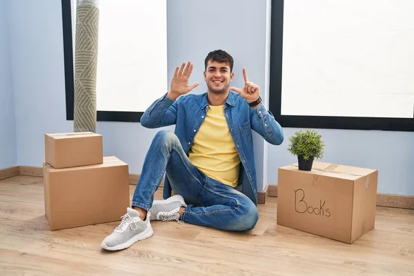Genç Spanyol Adam Yeni Evinde Yerde Oturuyor Yedi Numaralı Parmaklarıyla — Stok fotoğraf