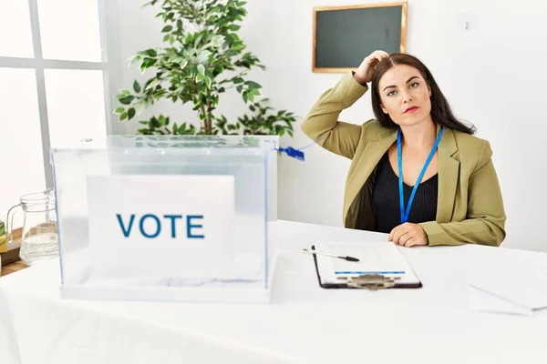 Young Brunette Woman Sitting Election Table Voting Ballot Confuse Wonder — Stock Photo, Image