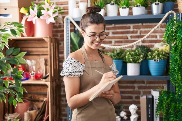 Jonge Mooie Spaanse Vrouw Bloemist Glimlachend Zelfverzekerd Schrijven Notebook Bij — Stockfoto