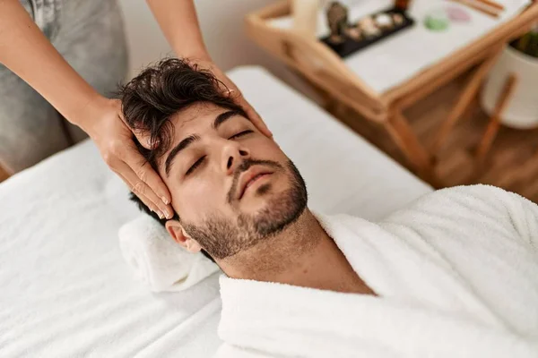 Man relaxed reciving head massage at beauty center.