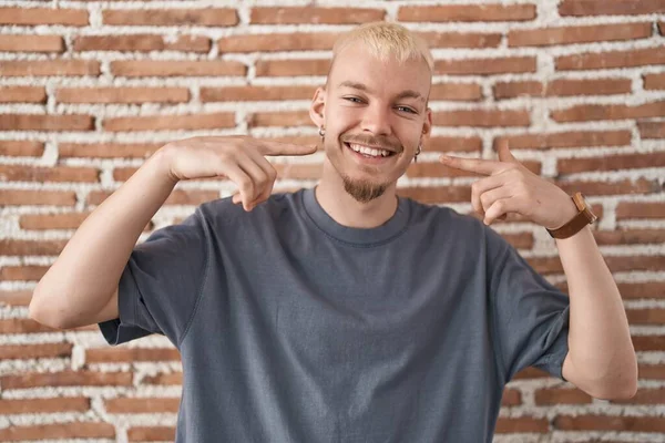 Joven Hombre Caucásico Pie Sobre Pared Ladrillos Sonriendo Alegre Mostrando —  Fotos de Stock