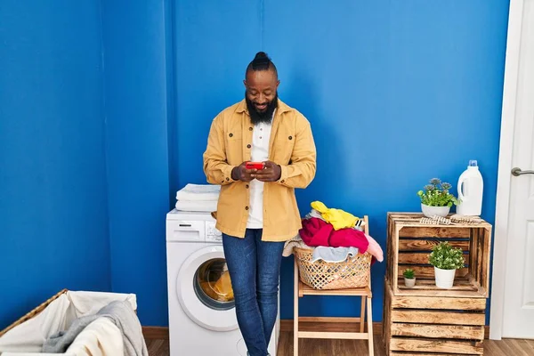 Mladý Africký Američan Pomocí Smartphone Čeká Pračku Prádelně — Stock fotografie