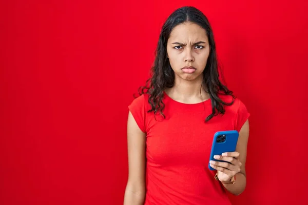 Genç Brezilyalı Kadın Kırmızı Arka Planda Akıllı Telefon Kullanıyor Şüpheci — Stok fotoğraf