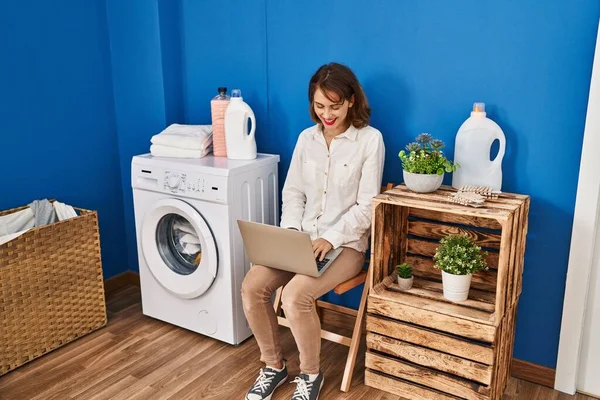Young Caucasian Woman Using Laptop Waiting Washing Machine Laundry Room — Stockfoto