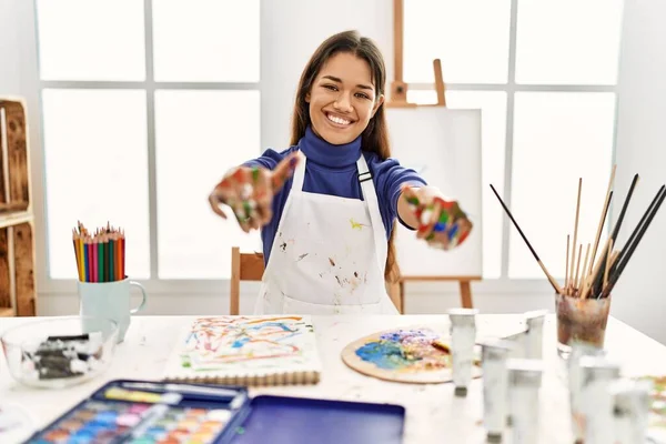 在艺术工作室里 年轻的黑发女人 手绘着彩绘 赞成用手做积极的手势 微笑着竖起大拇指 为成功感到高兴 优胜手势 — 图库照片