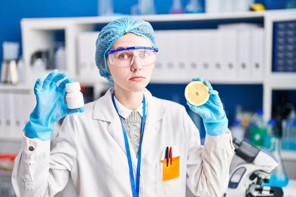 Beautiful Woman Working Scientist Laboratory Holding Pills Lemon Skeptic Nervous — Stock Photo, Image