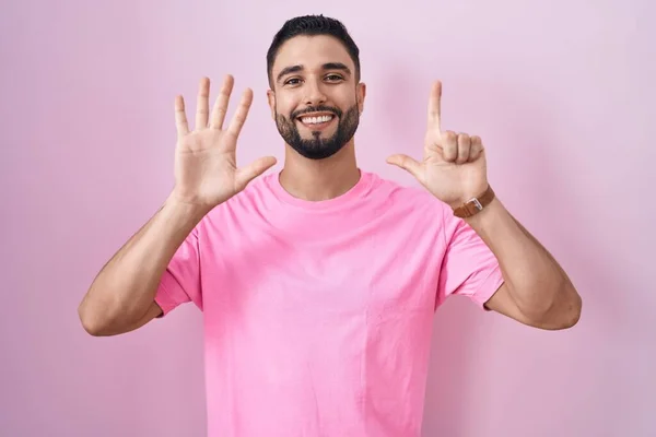 Spaanse Jongeman Staande Roze Achtergrond Tonen Wijzen Met Vingers Nummer — Stockfoto