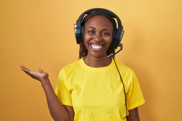 Африканская Американка Слушает Музыку Помощью Наушников Улыбаясь Веселым Подарком Указывая — стоковое фото