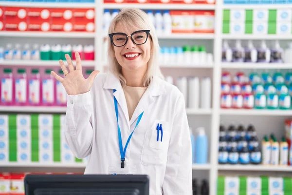 Молодая Белая Женщина Работающая Аптеке Показывает Пальцем Номер Пять Улыбаясь — стоковое фото
