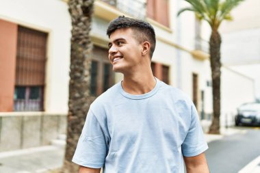 Sokakta kendinden emin gülümseyen İspanyol genç adam.