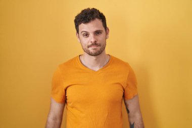 Sarı arka planda duran İspanyol genç adam uykulu ve yorgun görünüyor, yorgunluktan bitkin ve akşamdan kalma, sabahları tembel gözler.. 