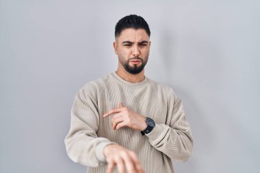 Soyutlanmış arka planda duran genç yakışıklı adam tiksindirici tepki verdiği için hoşnutsuz ve ürkek bir ifade takınıyor.. 