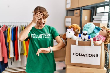 Bağışta gönüllü tişört giyen beyaz güzel bir kadın saat saatine bakıyor endişeli, geç kalmaktan korkuyor. 