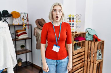 Young caucasian woman working as manager at retail boutique afraid and shocked with surprise expression, fear and excited face. 