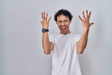 Tecrit edilmiş arka planda duran İspanyol adam başarı için deli ve çılgınlığı kutluyor kollarını kaldırmış ve gözlerini kapatmış heyecanla bağırıyor. Kazanan konsept 