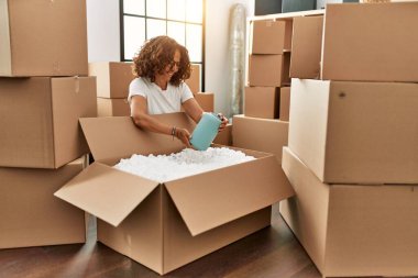 Orta yaşlı İspanyol kadın gülümsüyor kendine güvenen yeni evine taşınıyor