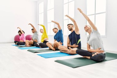 Bir grup genç, spor merkezinde yoga eğitimi alıyor..