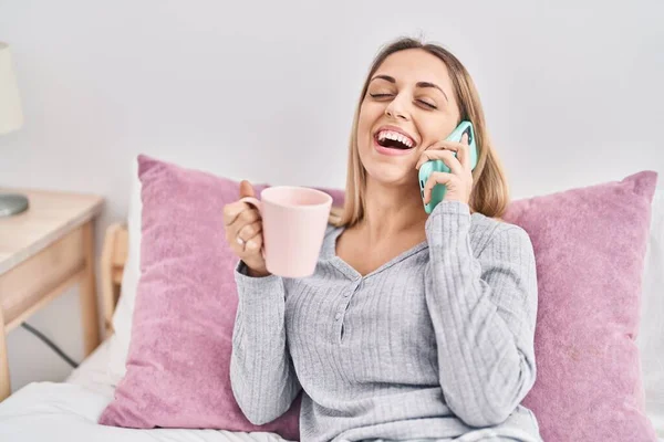 Jonge Vrouw Drinken Kopje Koffie Praten Smartphone Zitten Bed Slaapkamer — Stockfoto