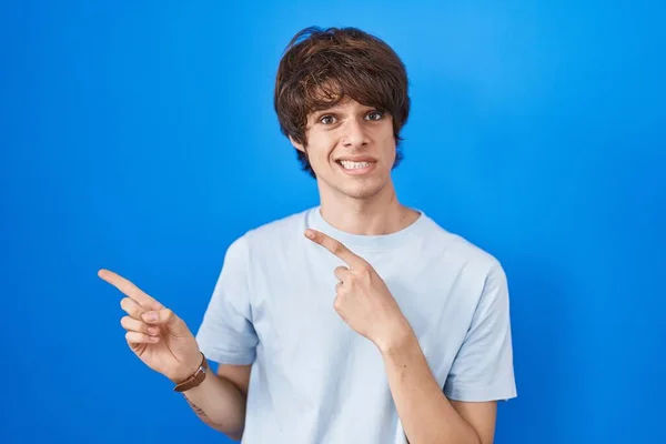 Hispánec Mladý Muž Stojící Nad Modrým Pozadím Ukazuje Stranou Ustaraný — Stock fotografie