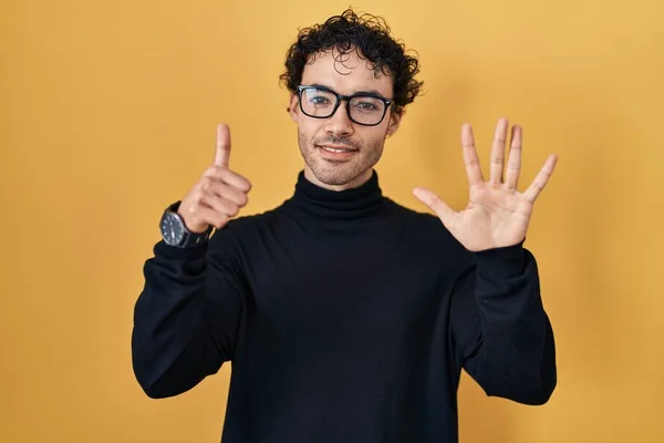 Hispanic Man Standing Yellow Background Showing Pointing Fingers Number Six — Stockfoto