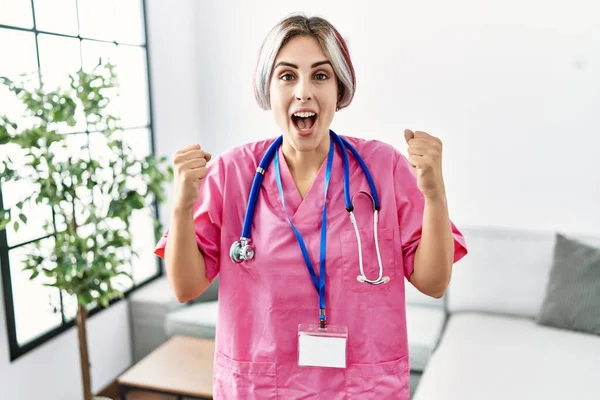 Ung Vacker Kvinna Bär Läkare Uniform Och Stetoskop Firar Förvånad — Stockfoto