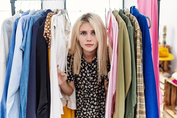 Young Blonde Woman Searching Clothes Clothing Rack Relaxed Serious Expression — Stock Photo, Image