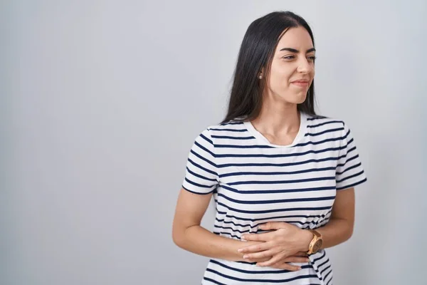 年轻的黑发女人穿着条纹T恤 双手放在肚子上 因为消化不良 痛苦不堪 疼痛的概念 — 图库照片