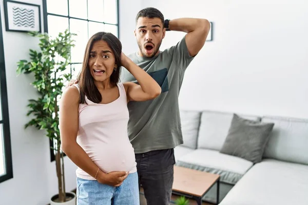 若いです異人種間のカップル予想赤ちゃん 接触妊娠中の腹クレイジーと恐怖で手で頭 恐怖と驚きのショックでオープン口 — ストック写真