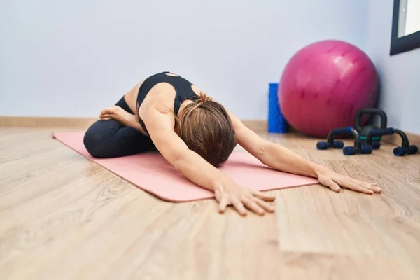 Young woman stretching at sport center