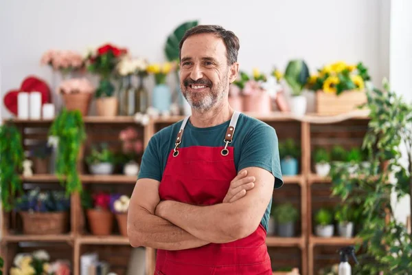 Middle age man florist smiling confident standing with arms crossed gesture at florist
