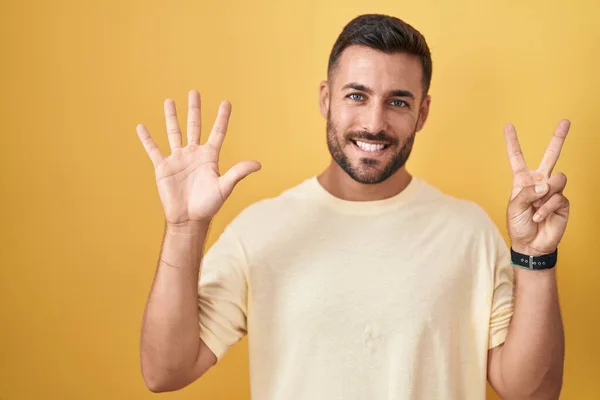 Pohledný Hispánec Stojící Nad Žlutým Pozadím Ukazující Ukazující Prsty Číslo — Stock fotografie
