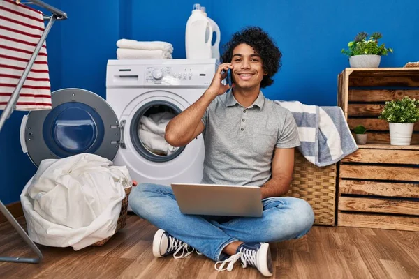 Joven Hispano Usando Laptop Hablando Smartphone Esperando Lavadora Lavandería — Foto de Stock