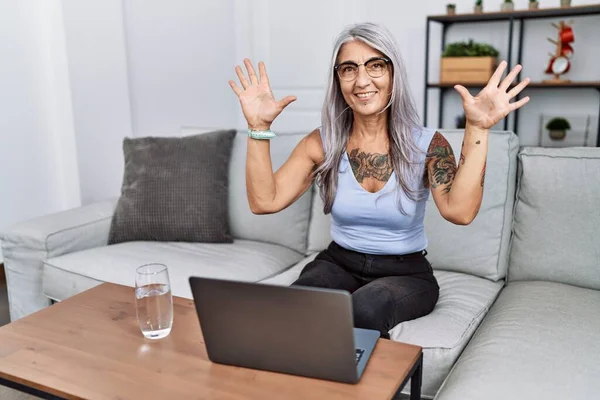 自信と幸せ笑顔ながら 自宅でラップトップを使用した中年白髪の女性は 指の数10を示し 指摘します — ストック写真