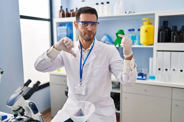 Joven Hispano Con Barba Trabajando Laboratorio Científico Sosteniendo Cinta Verde —  Fotos de Stock