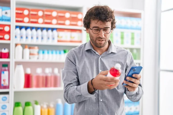 Fiatal Spanyol Férfi Ügyfél Használ Smartphone Holding Gyógyszer Palack Gyógyszertárban — Stock Fotó