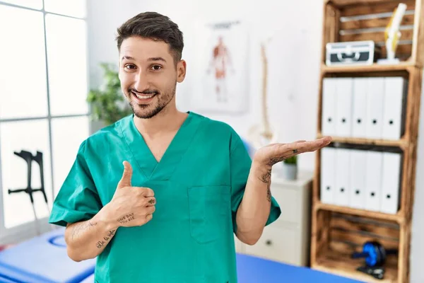 Homem Fisioterapeuta Jovem Trabalhando Clínica Recuperação Dor Mostrando Palma Mão — Fotografia de Stock