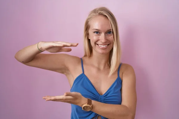 Young Caucasian Woman Standing Pink Background Gesturing Hands Showing Big — Stock Fotó